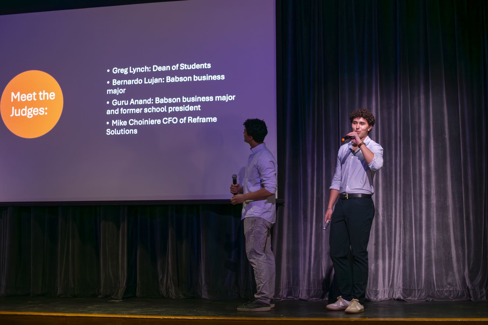 Hosts introducing the Tiger Cage judging panel on stage at Suffield Academy