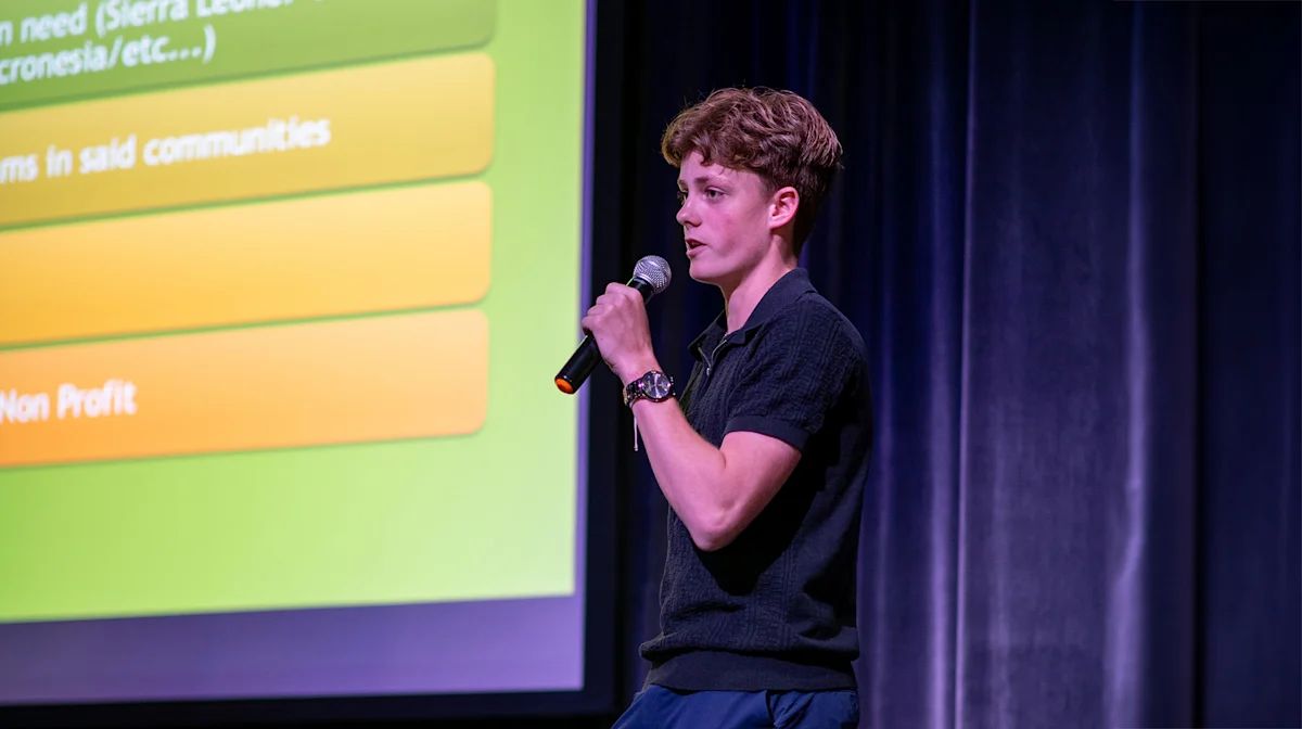 A student presenter pitching on stage at Tiger Cage